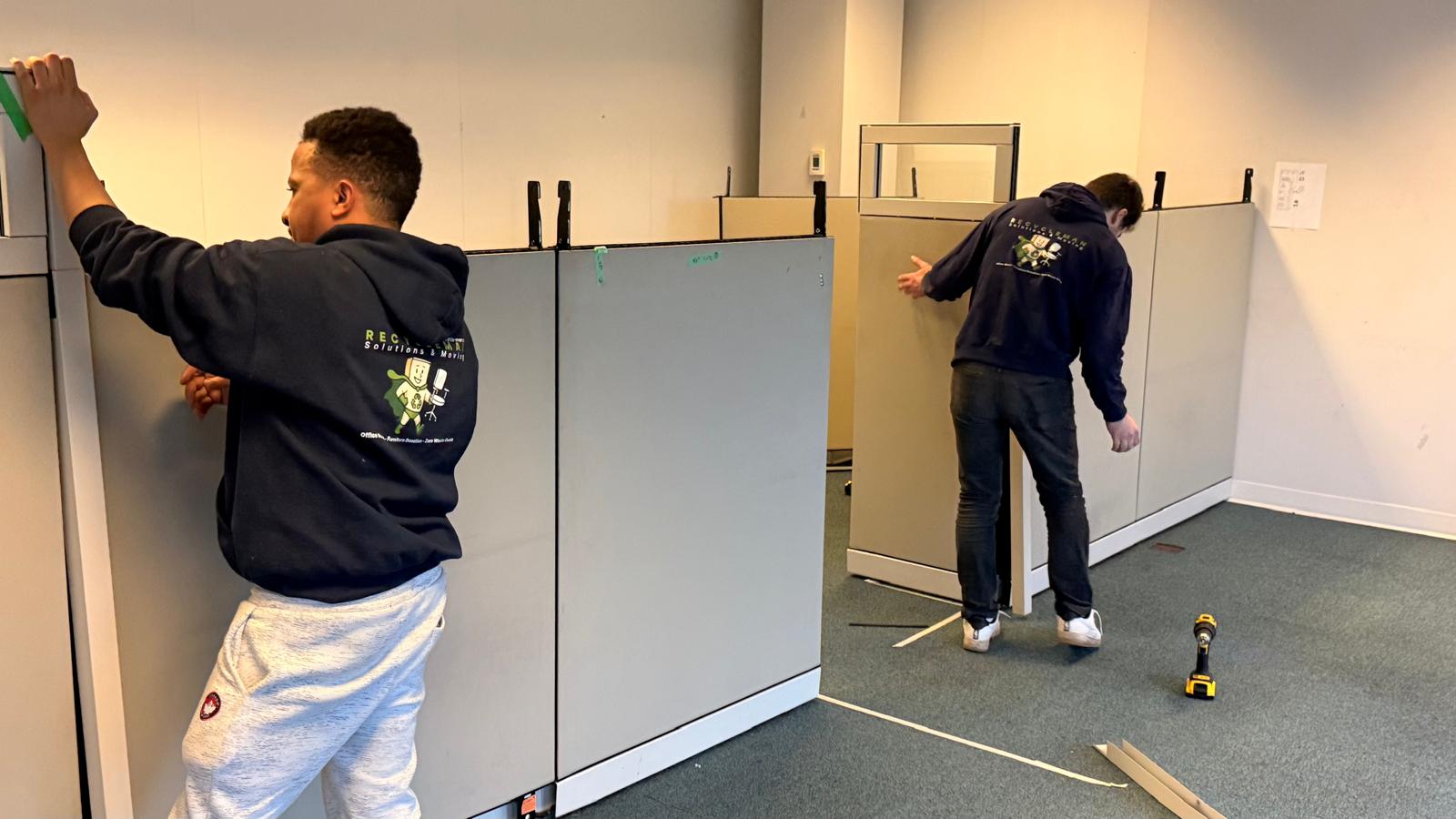 Team systematically moving and sorting office panels during a workspace clearance